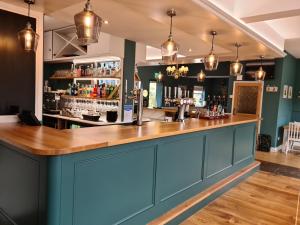 a bar in a pub with blue cabinets at The Red Lion in Kilsby