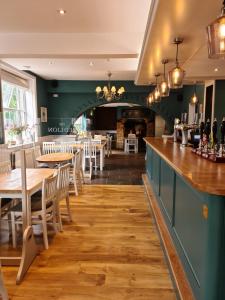 un restaurante con mesas y sillas y un bar en The Red Lion, en Kilsby