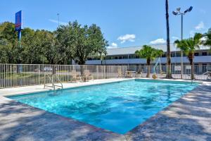 a swimming pool with blue water in front of a building at Studio 6-Jacksonville, FL - Baymeadows in Jacksonville