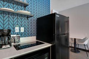 a kitchen with a refrigerator and a stove at Studio 6-Jacksonville, FL - Baymeadows in Jacksonville