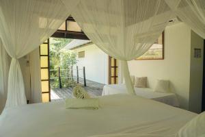 A bed or beds in a room at Le Coconut Lodge