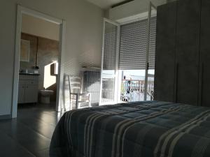 una camera con letto e una cucina con balcone di LE MURA Foresteria a Grassobbio