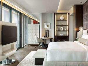 a living room with a large bed and a television at Fairmont Quasar Istanbul Hotel in Istanbul
