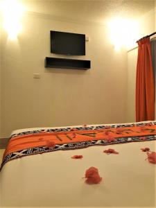 a bedroom with a bed with a tv on the wall at Suva Motor Inn in Suva