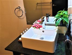 a bathroom with a sink with flowers in it at Suva Motor Inn in Suva