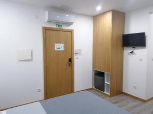 Uma televiso e/ou sistema de entretenimento em ALOJAMENTO GIRASSOL - Guest House - Quarto com casa de banho privativa