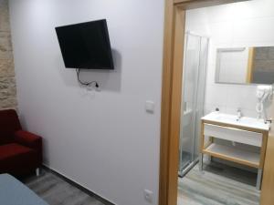 Uma televiso e/ou sistema de entretenimento em ALOJAMENTO GIRASSOL - Guest House - Quarto com casa de banho privativa
