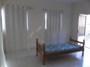 a bedroom with a wooden bed in a room at Sitio Cantinho Verde Cedro in Cunha