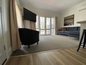 a living room with a couch and a television at Campaspe Lodge in Echuca