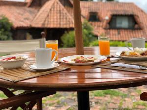 a wooden table with plates of food and drinks on it at Hacienda la Odisea in Subachoque