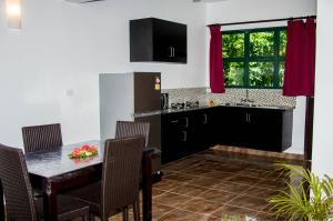 uma cozinha com uma mesa e cadeiras e uma cozinha com uma janela em Grand West Villas em Nadi