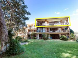 ein großes Apartmenthaus mit einem grünen Hof in der Unterkunft Bay Parklands 68 aircon pool tennis court communal spa in Shoal Bay