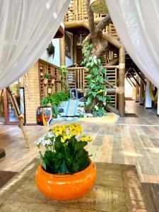 an orange vase with flowers in the middle of a room at Pousada João Sol in Praia do Forte