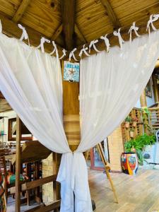 a white curtain hanging from a wooden ceiling at Pousada João Sol in Praia do Forte