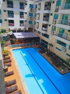 - une vue sur la piscine en face d'un bâtiment dans l'établissement Vivendas Summer Beach Apto Particular, à Bombinhas