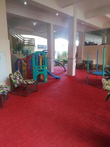 a large room with a playground on a red carpet at Vivendas Summer Beach Apto Particular in Bombinhas