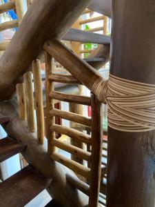 a wooden spiral staircase in a wooden house at Pousada João Sol in Praia do Forte