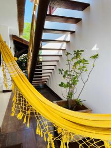 a yellow hammock in a room with a staircase at Pousada João Sol in Praia do Forte