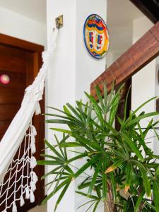 a crest on a wall next to a plant at Pousada João Sol in Praia do Forte