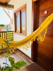 a yellow hammock hanging from a door of a house at Pousada João Sol in Praia do Forte