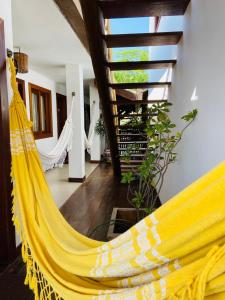a yellow hammock in a room with a ceiling at Pousada João Sol in Praia do Forte