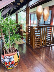 a large vase with a plant on a wooden floor at Pousada João Sol in Praia do Forte