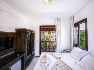 a bedroom with a bed and a flat screen tv at Pousada João Sol in Praia do Forte