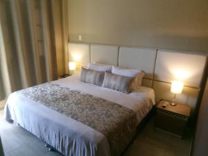 een slaapkamer met een groot bed met 2 lampen bij Hotel Salento Plaza in Salento