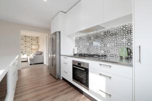 a kitchen with white cabinets and a stove top oven at Sapphire Spring Rise in Wanaka