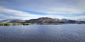 a large body of water with mountains in the background at Uros Suma Jakaa Lodge Titicaca Experience in Puno