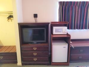 uma televisão sentada numa cómoda com um micro-ondas em Americas Best Value Inn Arkansas City em Arkansas City