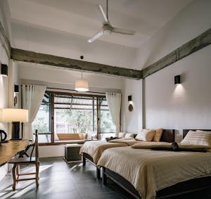 a bedroom with two beds and a ceiling fan at Palin Family Cottage in Chiang Rai