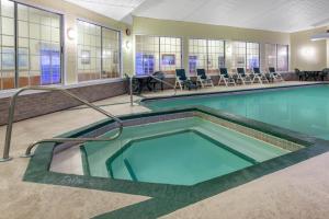 - une piscine avec des chaises et des tables dans un bâtiment dans l'établissement Apple Tree Inn; SureStay Collection by Best Western, à Petoskey