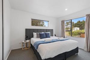 a bedroom with a large bed and a large window at North South Holiday Park in Christchurch