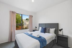a hotel room with a bed and a television at North South Holiday Park in Christchurch