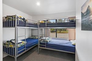 a row of bunk beds in a room at North South Holiday Park in Christchurch