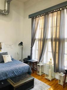 a bedroom with a bed and two large windows at UPDATED Amazing Bi -Level Condo minutes from water views of New York City in North Bergen