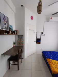 Habitación con mesa, cama y puerta en UNIE HOMESTAY, en Wakaf Che Yeh