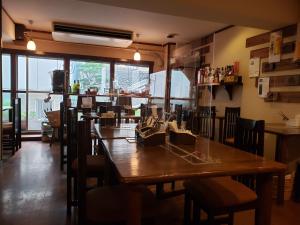 a restaurant with a large wooden table and chairs at GardenRoom bnb Yumyum in Nagasaki