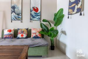 - une chambre avec un canapé vert et des peintures murales dans l'établissement i LIFE De'an, à Hualien
