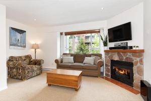 uma sala de estar com um sofá e uma lareira em Bear Lodge (Town Plaza) em Whistler