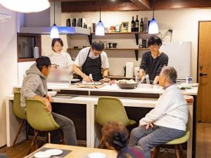 un grupo de personas en una cocina preparando comida en Wow! KANAZAWA STAY, en Kanazawa