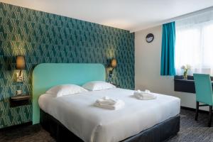 เตียงในห้องที่ Zenith Hotel Caen