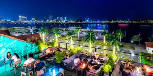 uma vista da cidade a partir de um bar no último piso à noite em Amanjaya Pancam Suites Hotel em Phnom Penh