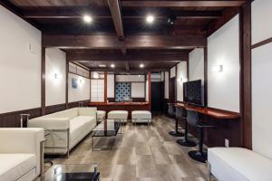 a living room with white couches and a bar at Wow! KANAZAWA STAY in Kanazawa
