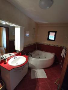 a bathroom with a tub and a toilet and a sink at Vila Sara in Chişoda