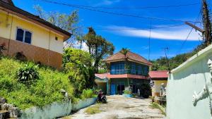 ein Haus mit Fliesenboden auf einer Straße in der Unterkunft Hotel Sayna in Sibolangit