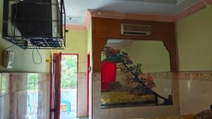 ein Wohnzimmer mit einem Spiegel und einem TV an der Wand in der Unterkunft Hotel Sayna in Sibolangit