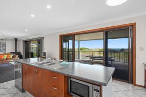 a kitchen with a counter top and a living room at Beach House at Moana - C21 SouthCoast Holidays in Moana