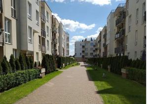 a walkway between buildings with a row of trees at Sunny Penthouse with roof gardens overlooking the Warsaw Palace of Culture in Pruszków